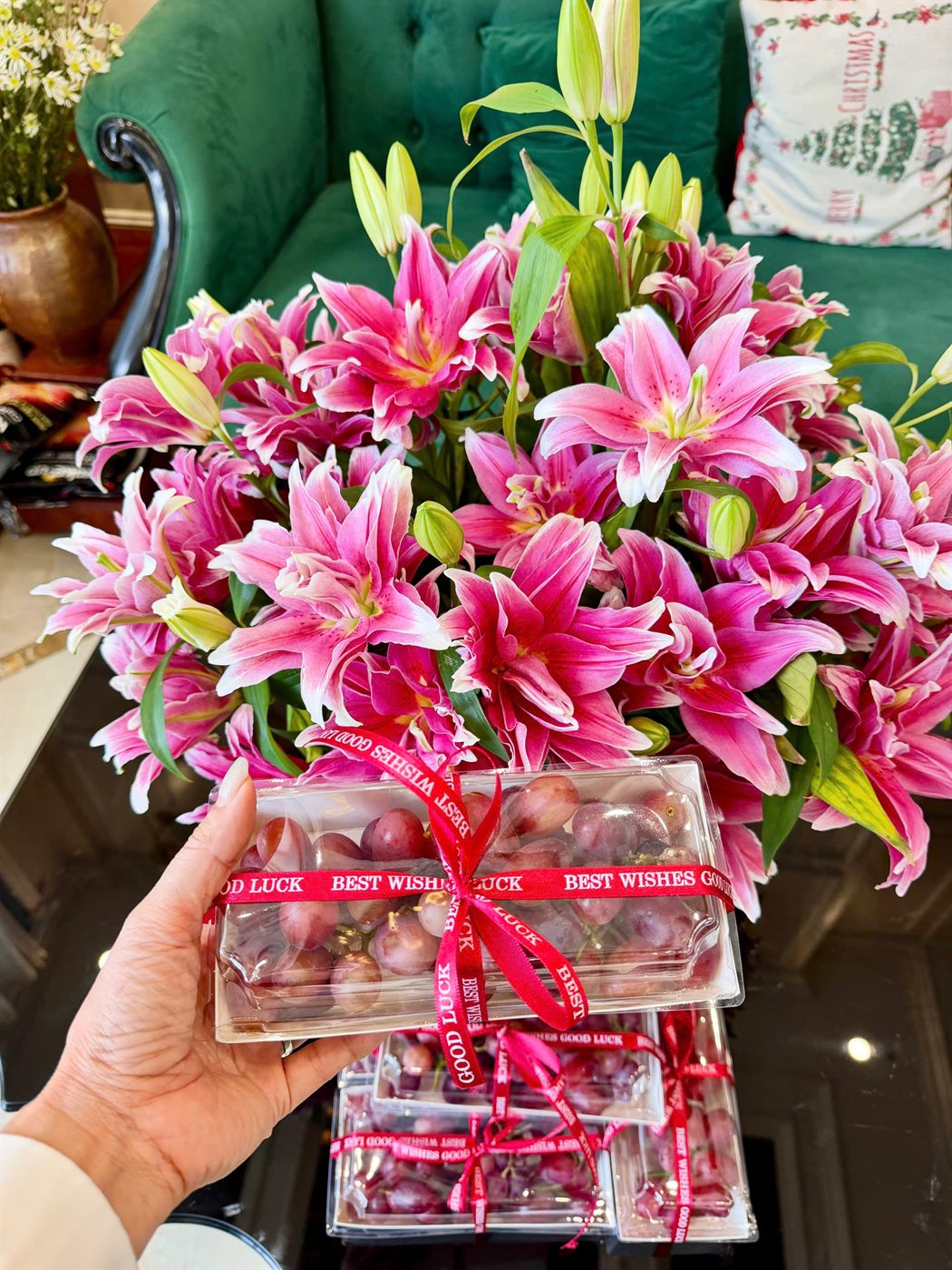 Hộp nho đỏ thắt ruy băng Best Wishes Good Luck bên bình hoa ly hồng ngày 20/10/2026